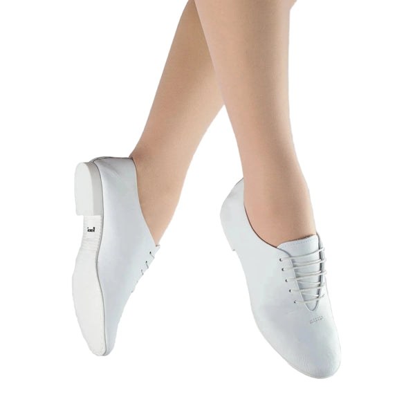 White jazz dance shoes worn by a person on a light gray background