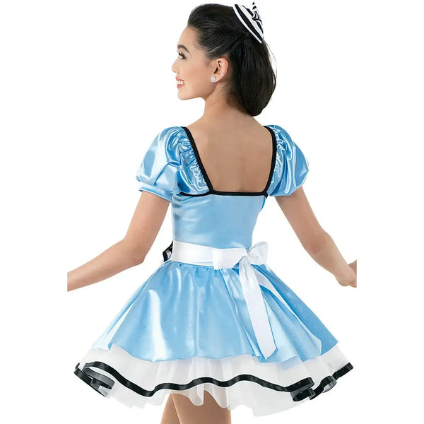 Girl wearing an Alice in Wonderland dance dress on a white background