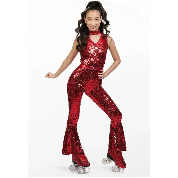 A person wearing a red sequin flared jumpsuit with metallic trim, dancing on roller skates.