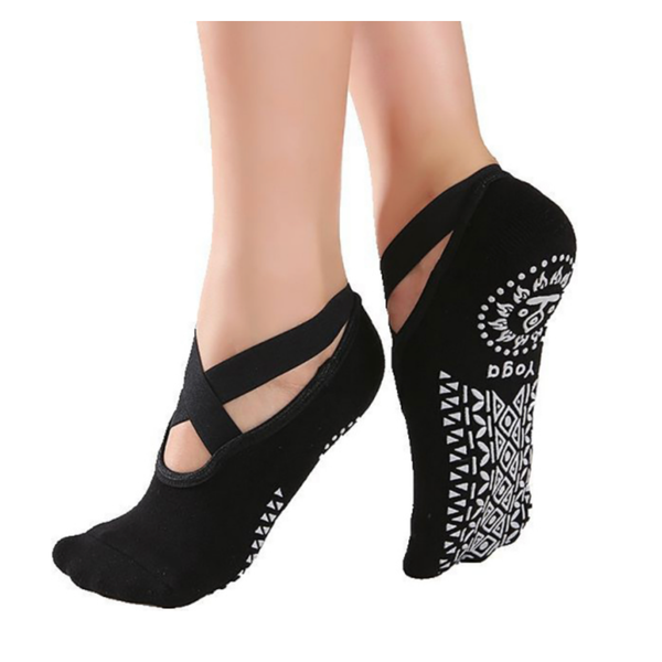 A pair of black non-slip yoga socks with a geometric pattern on the sole, designed to be worn during yoga practices.