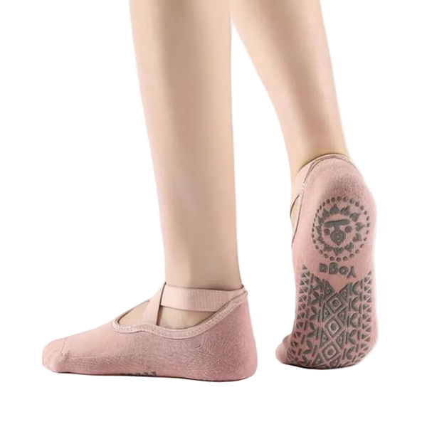A pair of pink non-slip yoga socks with a geometric pattern on the sole, designed to be worn during yoga practices.